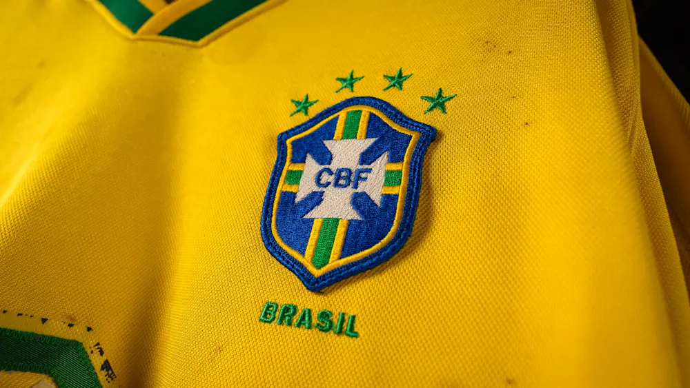 Yellow soccer jersey with a blue and green CBF emblem, four stars above and "Brasil" text below.