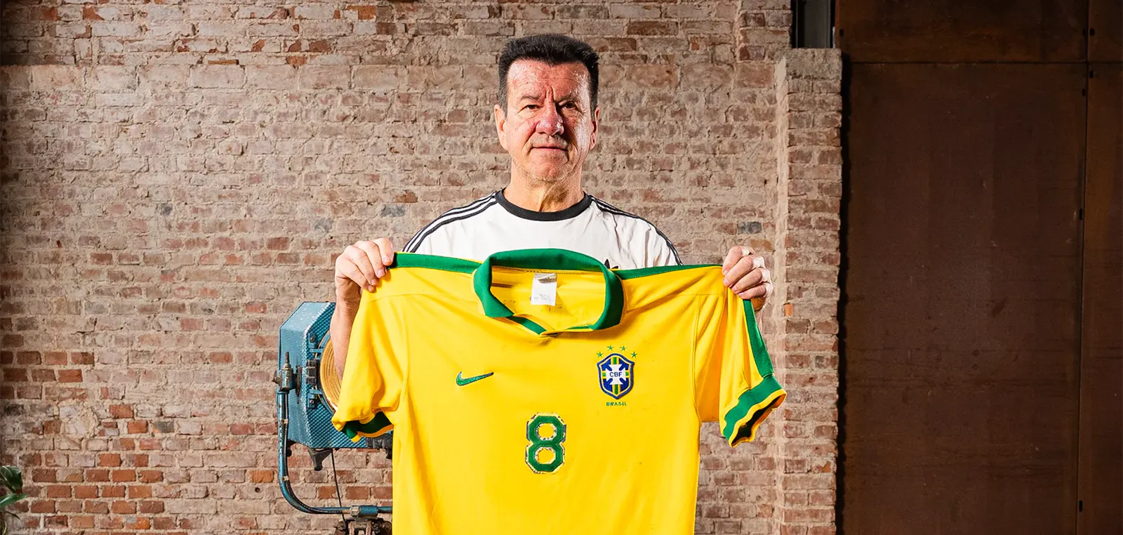 Dunga holds a yellow and green Brazil soccer jersey with number 8, part of his collection of auctions with MWS.